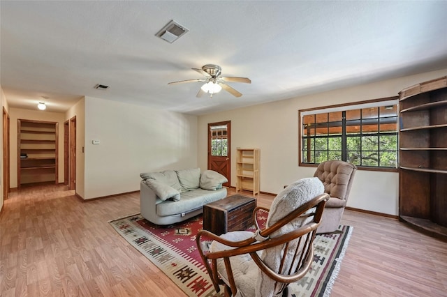 living room with light wood-type flooring and ceiling fan