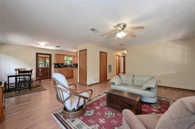 living room with light hardwood / wood-style floors and ceiling fan