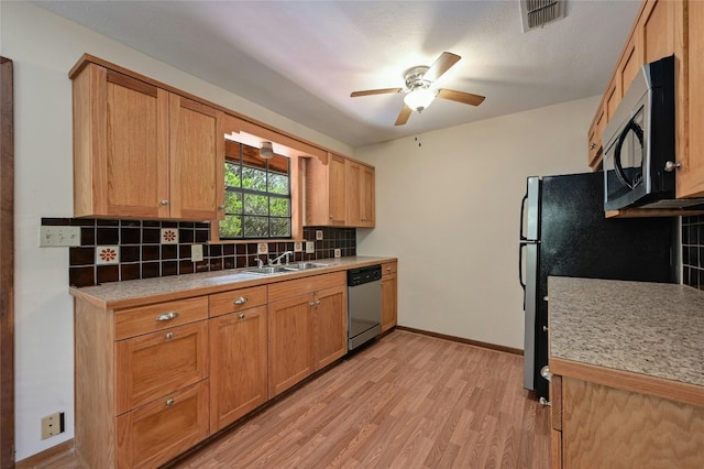 kitchen featuring ceiling fan, sink, backsplash, stainless steel appliances, and light hardwood / wood-style floors