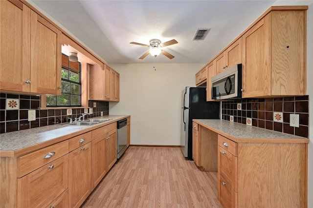 kitchen featuring ceiling fan, sink, tasteful backsplash, appliances with stainless steel finishes, and light hardwood / wood-style floors