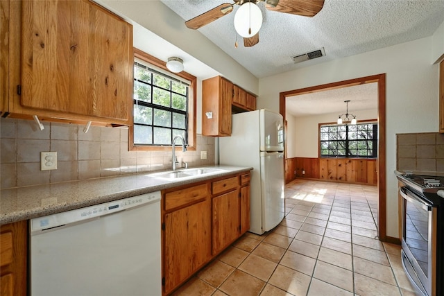 kitchen featuring white appliances, plenty of natural light, and tasteful backsplash