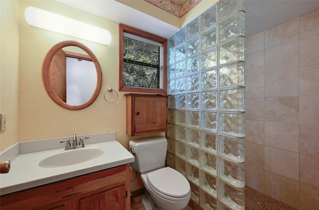 bathroom featuring tiled shower, vanity, and toilet