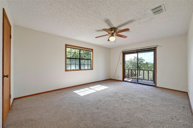 unfurnished room featuring a wealth of natural light, a textured ceiling, and ceiling fan