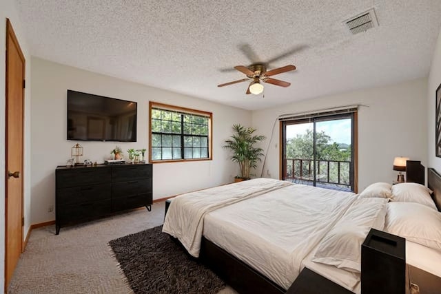 carpeted bedroom with ceiling fan, a textured ceiling, access to exterior, and multiple windows