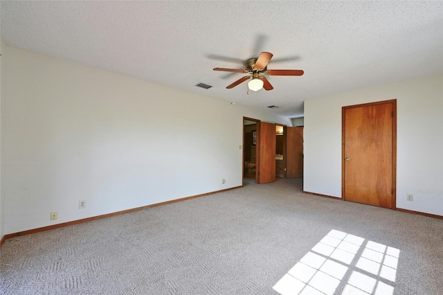 empty room with light carpet, a textured ceiling, and ceiling fan