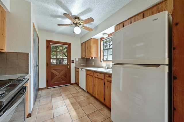 kitchen featuring decorative backsplash, white appliances, sink, and plenty of natural light