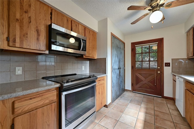 kitchen featuring ceiling fan, light tile patterned flooring, a textured ceiling, backsplash, and appliances with stainless steel finishes