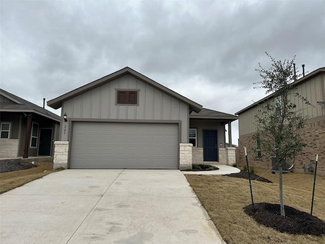 view of front of home featuring board and batten siding, concrete driveway, a garage, and stone siding