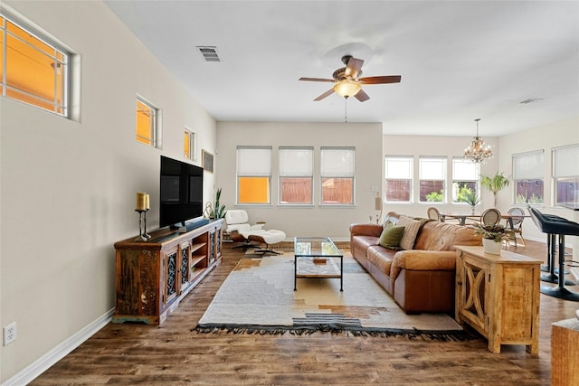 living room featuring dark hardwood / wood-style flooring and ceiling fan with notable chandelier