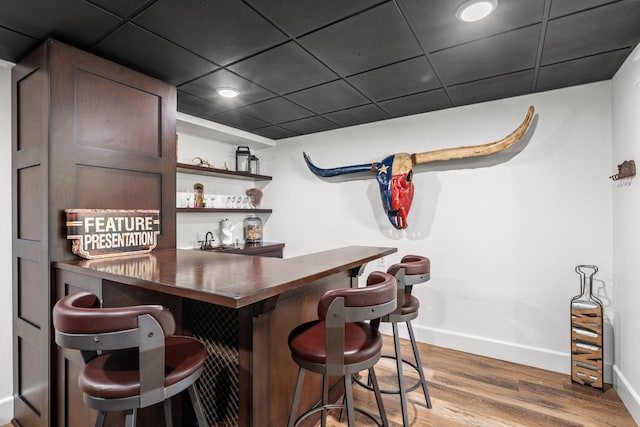 bar featuring hardwood / wood-style floors and a paneled ceiling