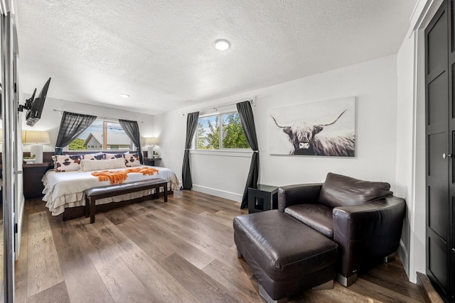 bedroom with wood-type flooring and a textured ceiling