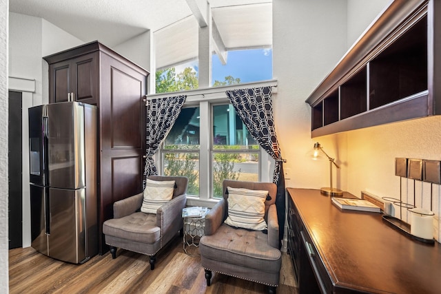 sitting room with lofted ceiling with beams and light wood-type flooring