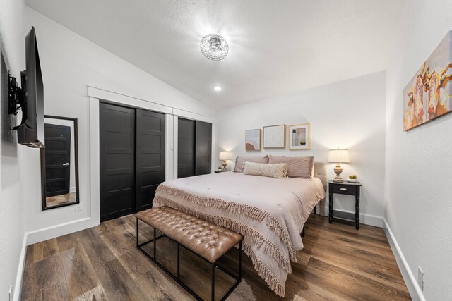 bedroom with vaulted ceiling and dark wood-type flooring