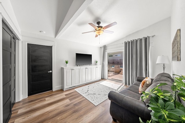 living room with hardwood / wood-style flooring, ceiling fan, and vaulted ceiling