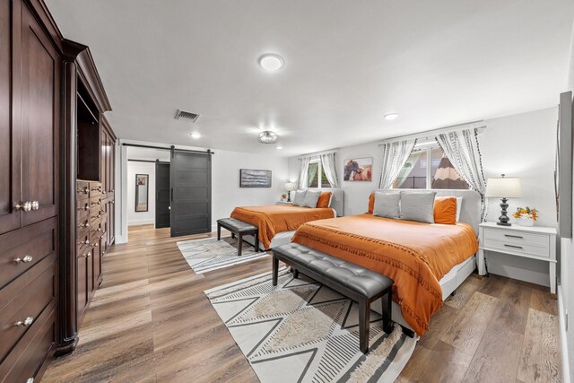 bedroom featuring light hardwood / wood-style floors and a barn door