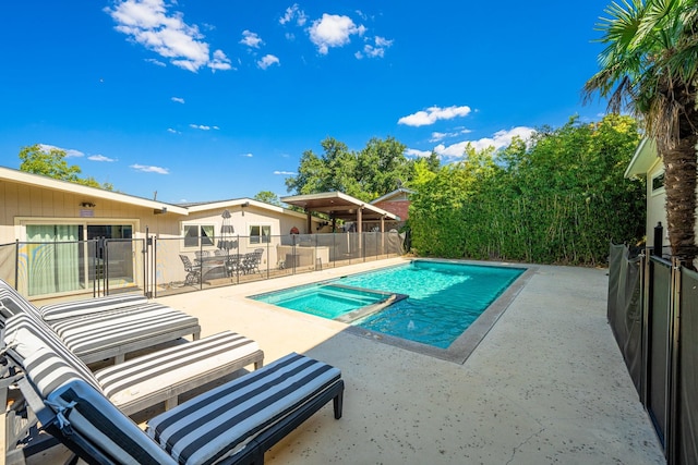 view of swimming pool featuring a patio area and an in ground hot tub