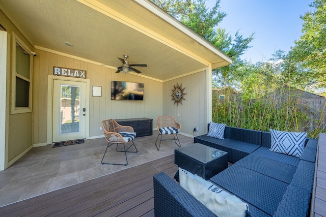 wooden terrace with ceiling fan and an outdoor living space