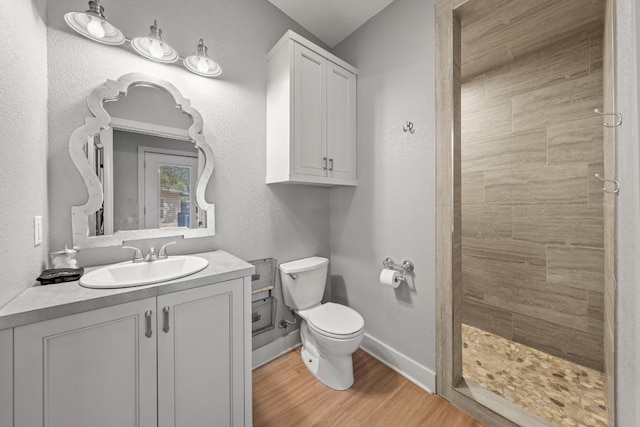 bathroom with toilet, vanity, a shower, and hardwood / wood-style floors