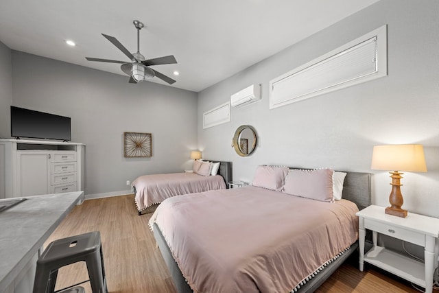 bedroom with an AC wall unit, light hardwood / wood-style floors, and ceiling fan