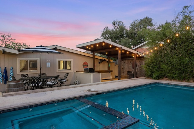 pool at dusk featuring a patio