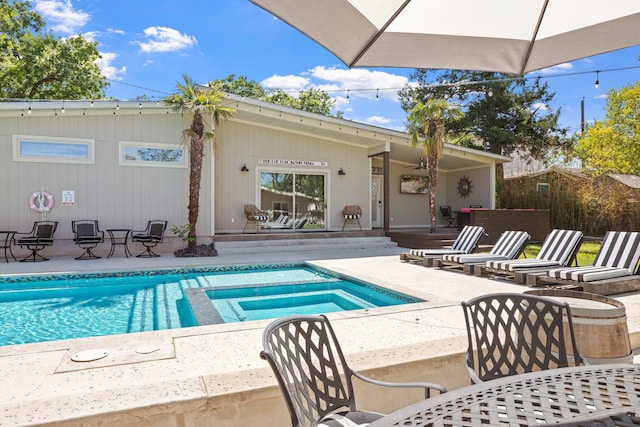 view of swimming pool with a patio area and an in ground hot tub