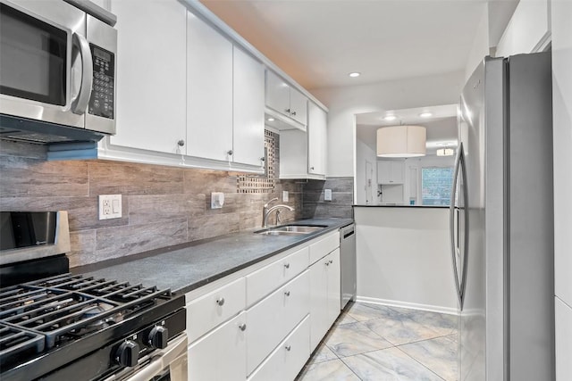 kitchen with white cabinets, appliances with stainless steel finishes, decorative backsplash, and sink