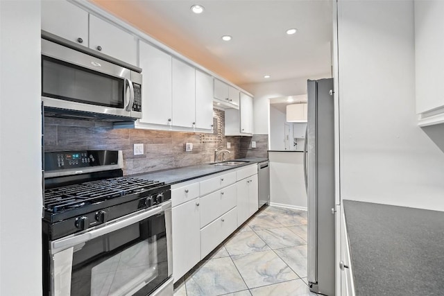 kitchen with tasteful backsplash, white cabinetry, sink, and appliances with stainless steel finishes