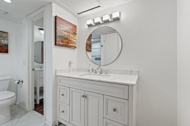 bathroom with tile patterned flooring, vanity, and toilet