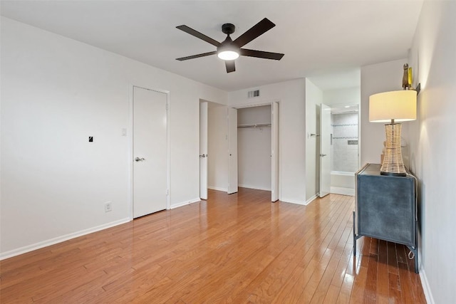 unfurnished bedroom featuring ceiling fan, wood-type flooring, and ensuite bathroom