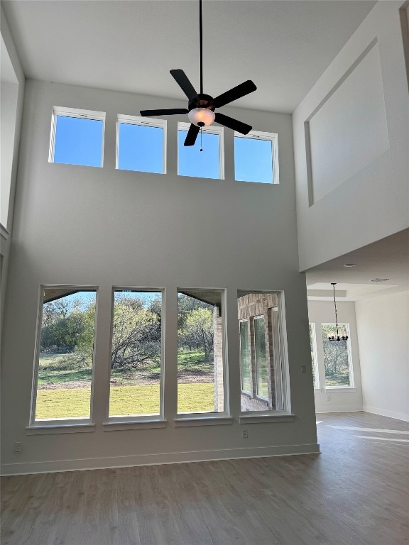 unfurnished living room with plenty of natural light, hardwood / wood-style floors, and a high ceiling