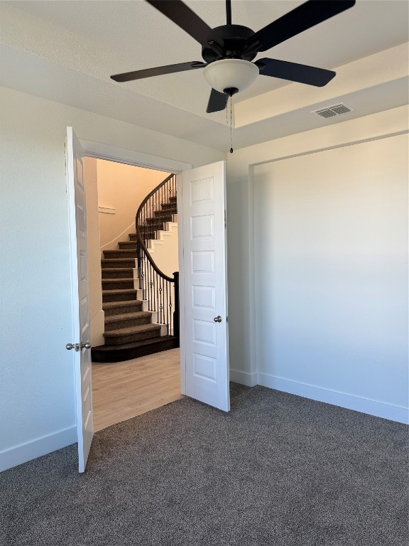 basement with ceiling fan and carpet floors