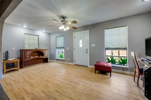 1807 Briar Hill Dr Unit A & B, Austin, TX 78741 - entrance foyer with light wood-style floors, a ceiling fan, a textured wall, a textured ceiling, and baseboards