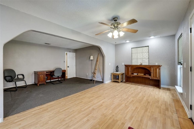 1807 Briar Hill Dr Unit A & B, Austin, TX 78741 - living area with arched walkways, wood finished floors, ceiling fan, and baseboards