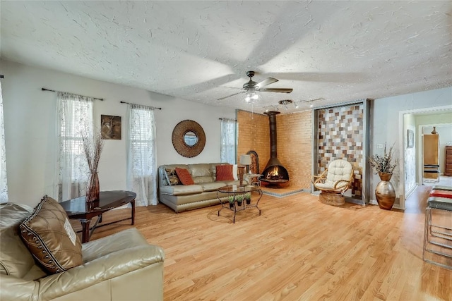 1807 Briar Hill Dr Unit A & B, Austin, TX 78741 - living area with wood finished floors, a wood stove, a ceiling fan, and a textured ceiling