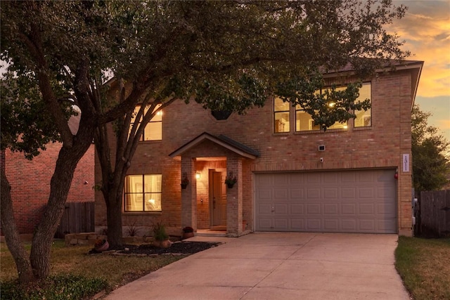 view of front of home with concrete driveway, brick siding, and fence