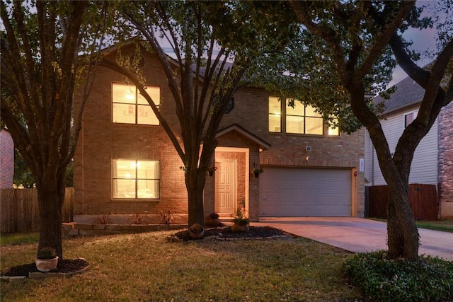 view of front of house with driveway, brick siding, an attached garage, and fence