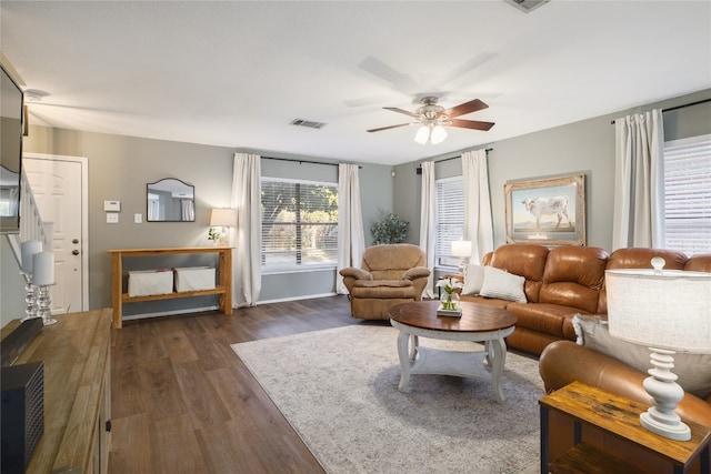 living room featuring ceiling fan and dark hardwood / wood-style flooring