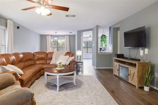 living room featuring ceiling fan and dark hardwood / wood-style floors