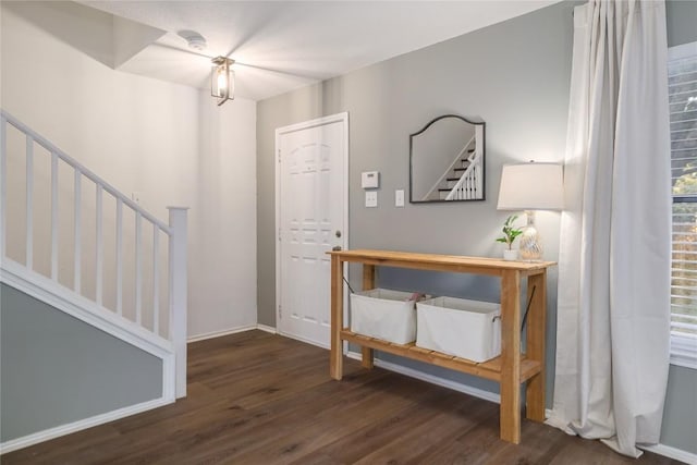 foyer featuring wood finished floors, baseboards, and stairs