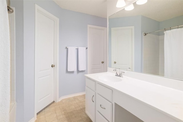 full bath with vanity and baseboards