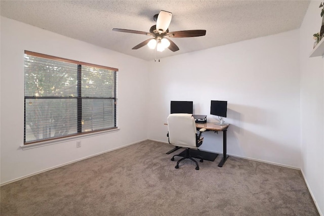 carpeted home office with ceiling fan and a textured ceiling