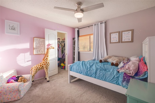 bedroom featuring ceiling fan, a closet, a spacious closet, and light colored carpet