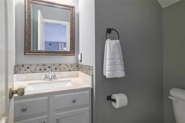 bathroom featuring decorative backsplash, vanity, and toilet