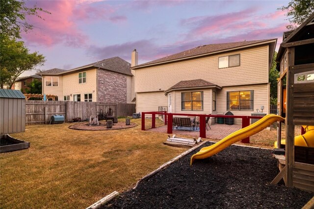 playground at dusk featuring a lawn