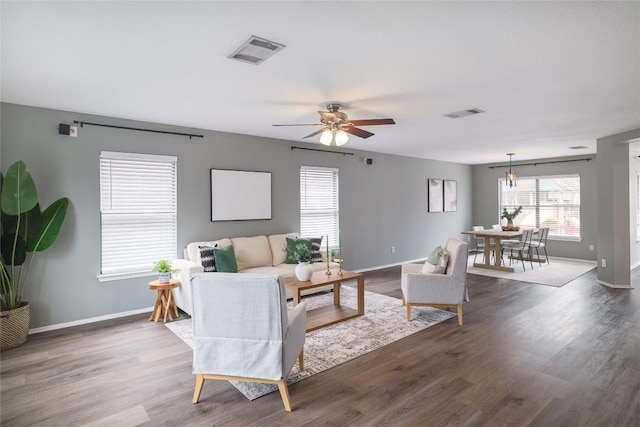 living area featuring visible vents, plenty of natural light, and wood finished floors