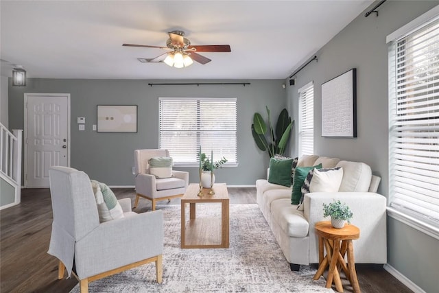 living area with ceiling fan, stairs, baseboards, and wood finished floors