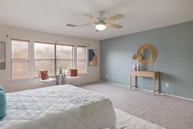 bedroom featuring carpet, visible vents, a textured ceiling, and baseboards