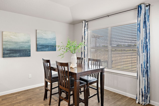 dining area featuring hardwood / wood-style floors and lofted ceiling