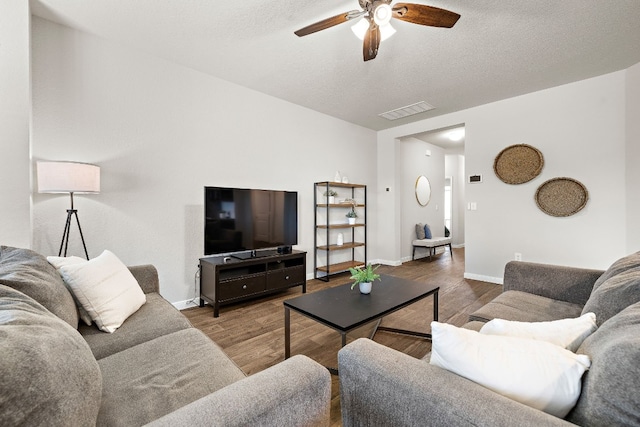 living room with hardwood / wood-style floors, a textured ceiling, and ceiling fan