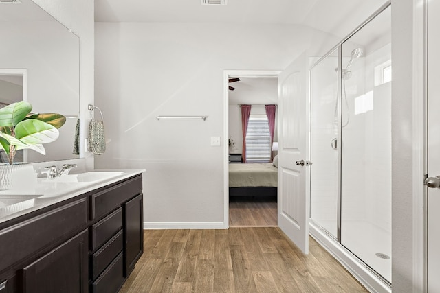 bathroom featuring hardwood / wood-style floors, vanity, and a shower with shower door